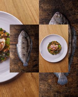 A plated gourmet dish featuring seafood, next to a raw flat fish on wooden surfaces, highlighting fine dining seafood.