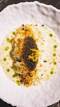 Elegant dish with caviar served on a creamy sauce in a fine dining setting at Le Pavillon.